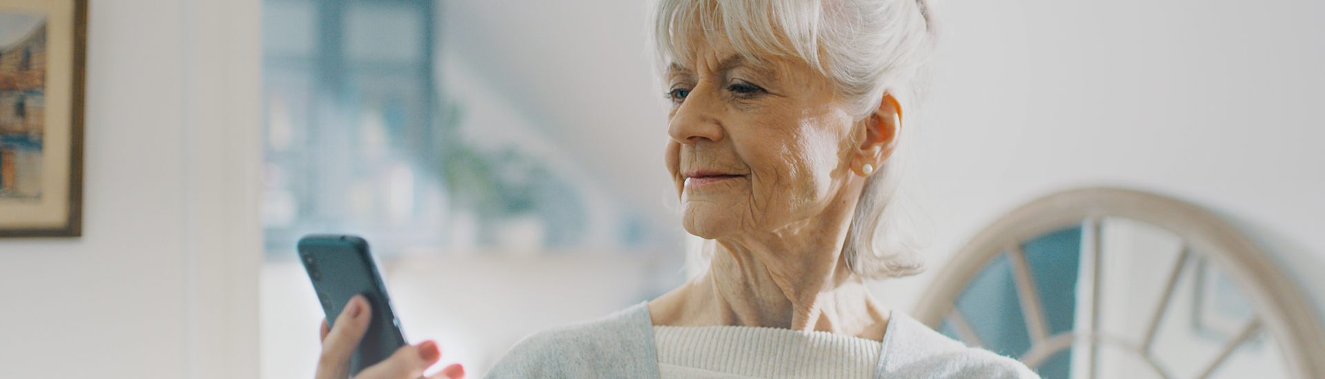 A senior woman looking at a Doro mobilephone